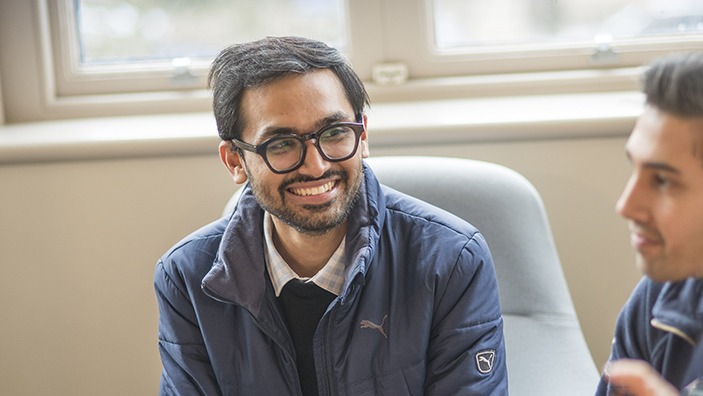 Cambridge MFin student smiling at colleagues.