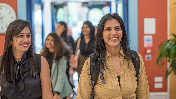 Cambridge MBA students walking into Cambridge Judge Business School.