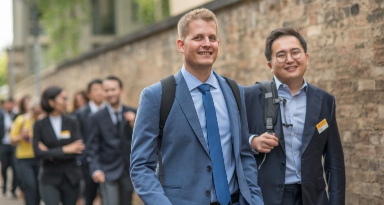 Students smiling while walking outside.