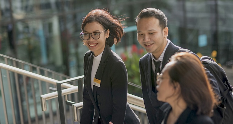 MBA students smiling outside.