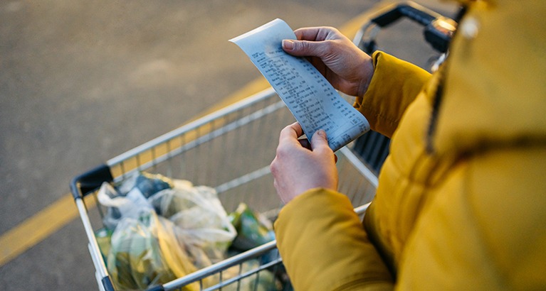 Person looking at shopping receipt.