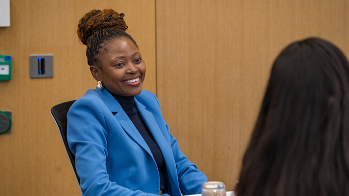 Woman in business suit smiling.