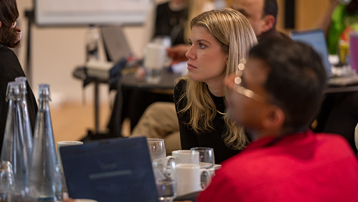 Woman listening intently in a classroom.