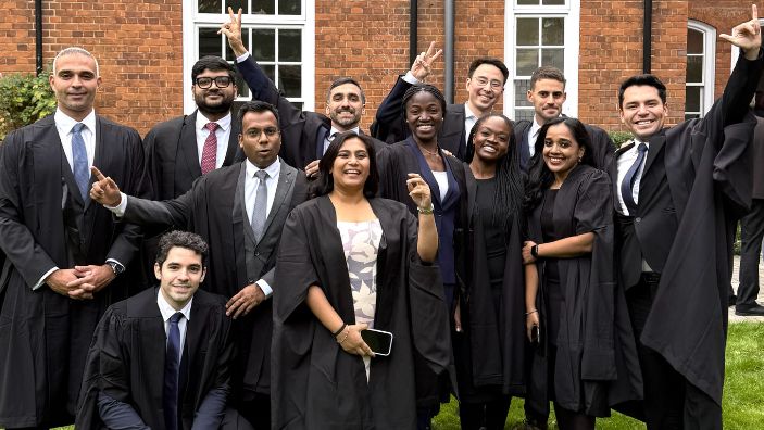 Alejandro Delgado with classmates at MFin graduation.