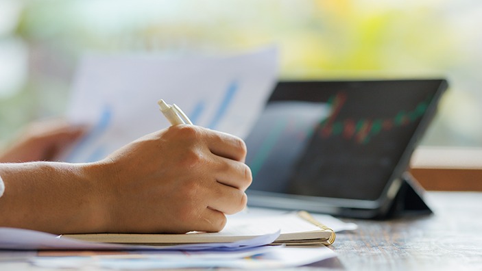 Writing notes after while analysing financial data.