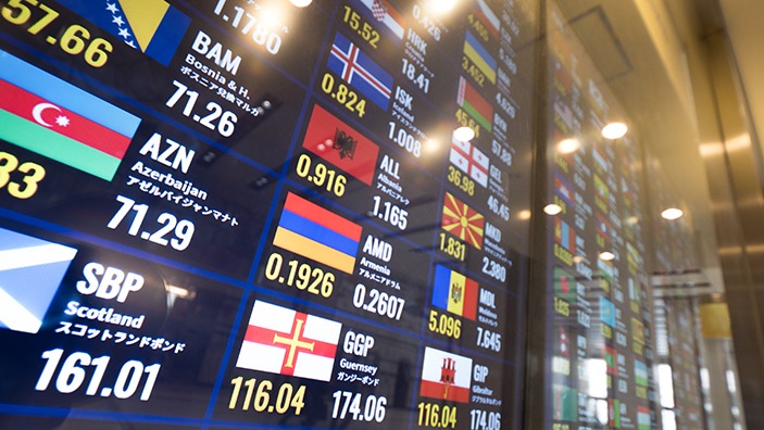 Currency rates on large floor to ceiling screen.