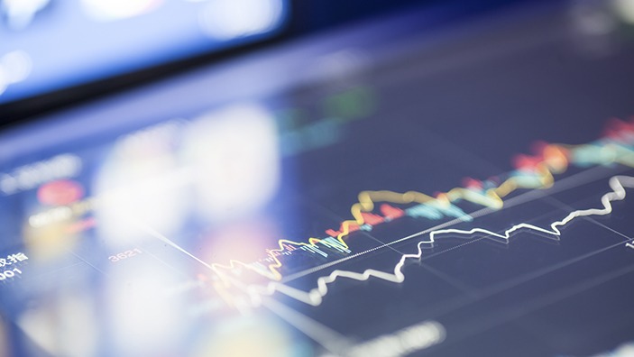 Tablet screen showing financial graphs.