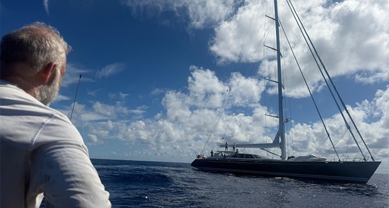 Mid-Atlantic, Ollie watches a luxury yacht sail past.