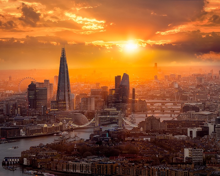 A beautiful sunset behind the London skyline with Tower Bridge and River Thames.