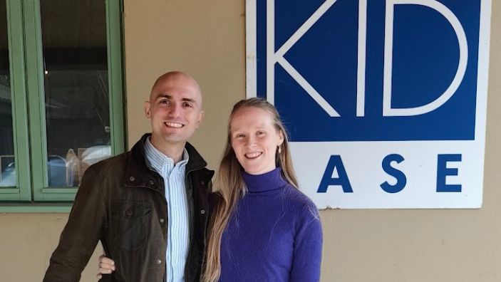 Carlos Arrebola with his wife Kathryn in front of the Kid Ease logo.