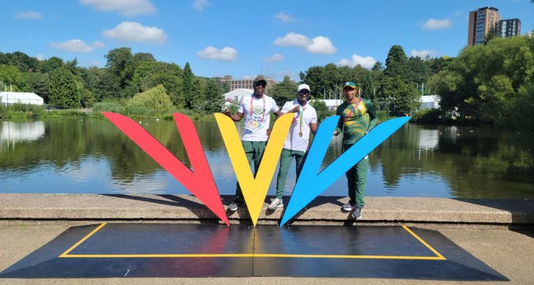 Jason Sewanyana with two athletes at the Commonwealth Games.
