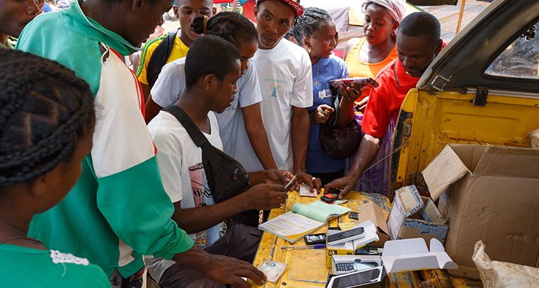 Man selling mobile phones at a rural Madagascan marketplace.