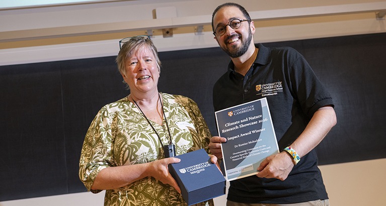 Dr Kamiar Mohaddes receives his climate change research award from Dr Lucinda Spokes.