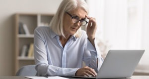 Women looking at her laptop with uncertainty.